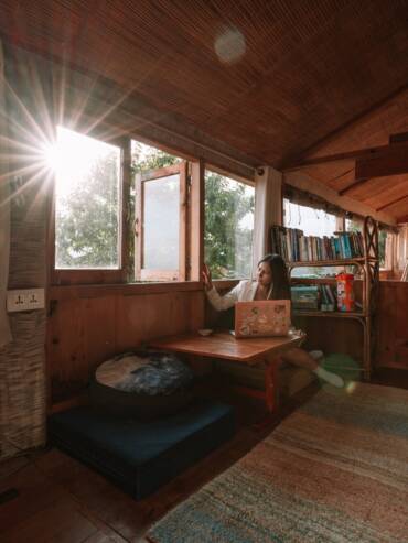 Digital nomad working from the mudhouse's common relaxing space at GlampEco Manali