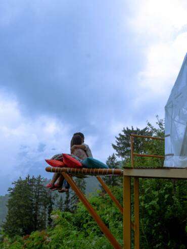 A couple relaxing at the outdoor area of their luxury GlampEco dome in Manali