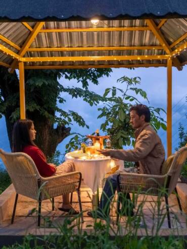 A couple celebrating with a romantic candle light dinner at GlampEco in Manali