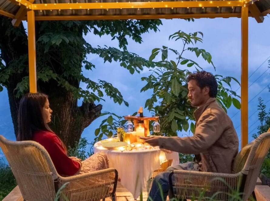 A couple celebrating with a romantic candle light dinner at GlampEco in Manali